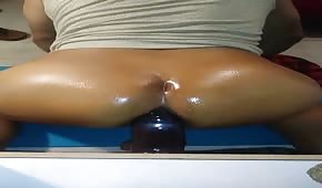 Oiled girl on a rubber dildo