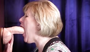 The mature lady is choking on a rubber cock