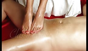 Oiled lady massages the cock with her feet